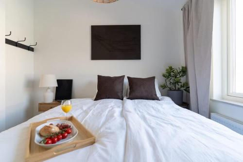 a tray of food on a bed with a plate of fruit at Chocolaty Warmth Home 3BR Flat with Cozy Balcony in Båstad