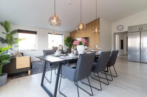 a kitchen and dining room with a table and chairs at Chocolaty Warmth Home 3BR Flat with Cozy Balcony in Båstad