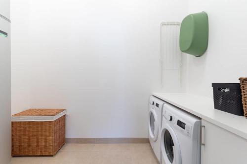 a laundry room with a washer and dryer at Chocolaty Warmth Home 3BR Flat with Cozy Balcony in Båstad