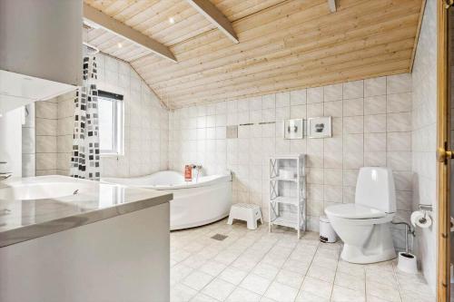 a bathroom with a tub and a toilet and a sink at 072-Ringkobing-Sivsangervej-11 in Ringkøbing
