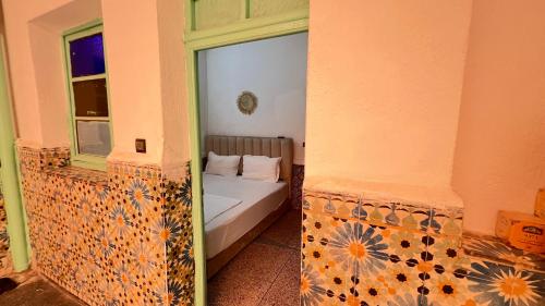 a small bedroom with a bed and a window at 里院 Daoudiate courtyard in Marrakech