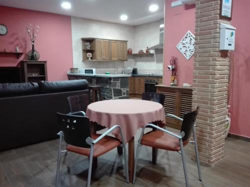 kuchnia i salon ze stołem i krzesłami w obiekcie Casa Rural Casa Queta w mieście Palomero