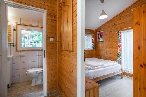 a bathroom with a toilet and a bed in it at Wojtek - domki letniskowe i pokoje, animacje, melex na plażę in Dziwnów