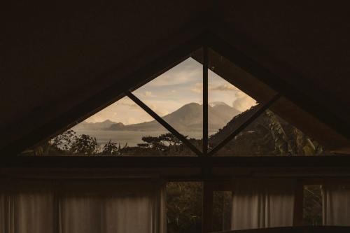 a window with a view of the mountains at Casa Awänímä - Luxury Permaculture Hotel & Eco-Retreat in Tzununá