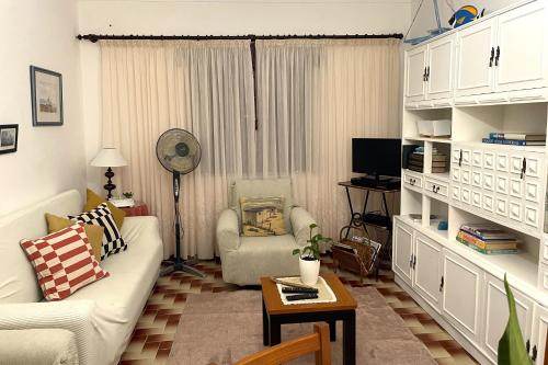 a living room with a couch and a table at CASA DAS MARÉS MILFONTES by Stay in Alentejo in Vila Nova de Milfontes
