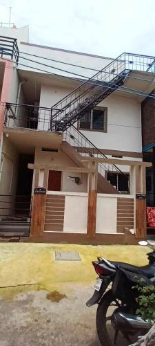 a house with a motorcycle parked in front of it at Sri Harini Homestay New Hampi in New Hampi