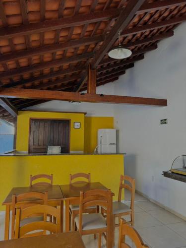 a dining room with a yellow table and chairs at Pousada Bons Ventos in Paraty