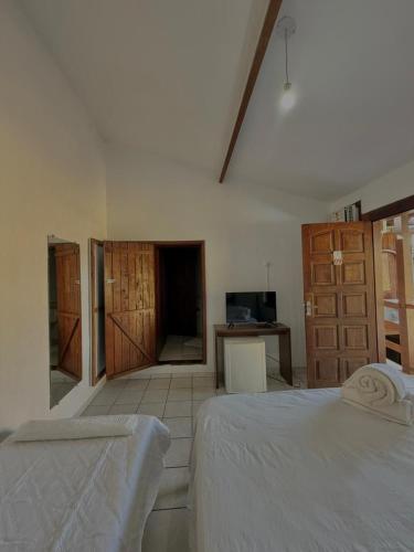 a bedroom with a bed and a tv in it at Pousada Bons Ventos in Paraty