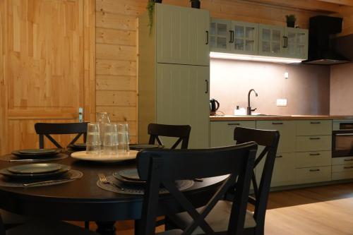 a dining room table with chairs and a kitchen at Jesse's Log Cabin in Norg