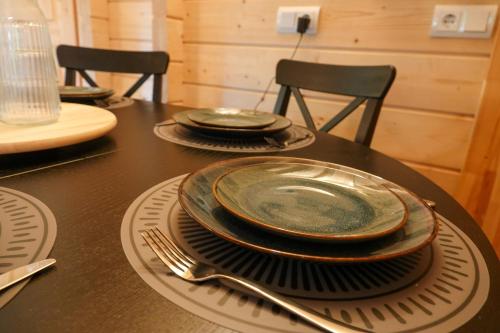 a table with plates and utensils on top of it at Jesse's Log Cabin in Norg