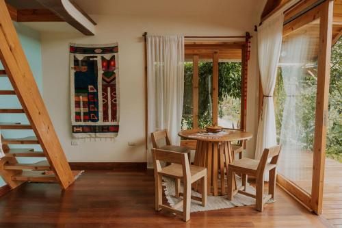 a dining room with a table and chairs and a window at Casa Awänímä - Luxury Permaculture Hotel & Eco-Retreat in Tzununá