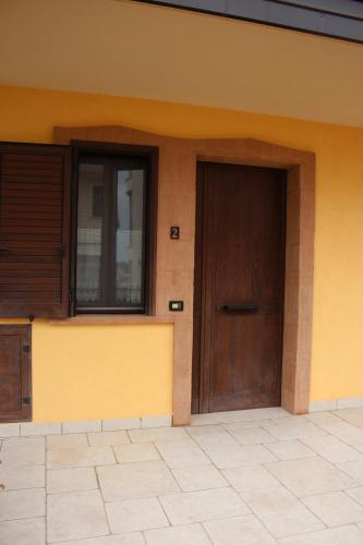 a building with a wooden door on the side of it at Affittacamere La Madonnina in San Giovanni Rotondo