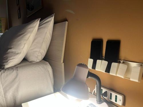 a room with a bed and a desk with a lamp at La Petite Maison in Augusta