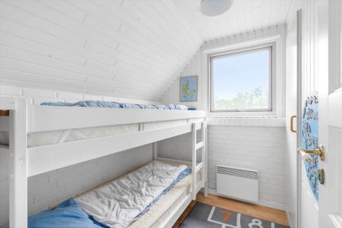 2 stapelbedden in een witte kamer met een raam bij 2250-Ringkobing-Vestklitvej-25 in Klegod