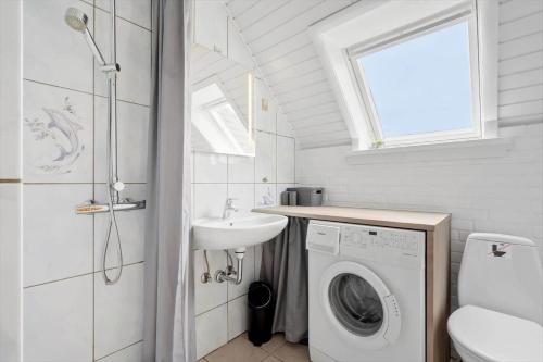 een badkamer met een wasmachine en een wastafel bij 2250-Ringkobing-Vestklitvej-25 in Klegod