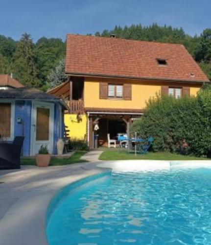 une maison avec une piscine devant une maison dans l'établissement GÎTE AVEC PISCINE CHEZ Véro, à Breitenbach-Haut-Rhin