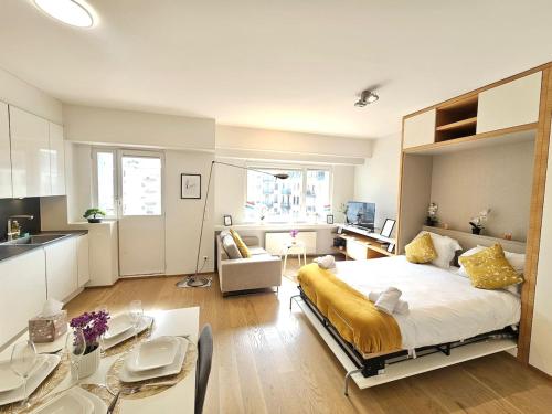 a bedroom with a large bed and a kitchen at Beautiful studio in Central Luxembourg in Luxembourg