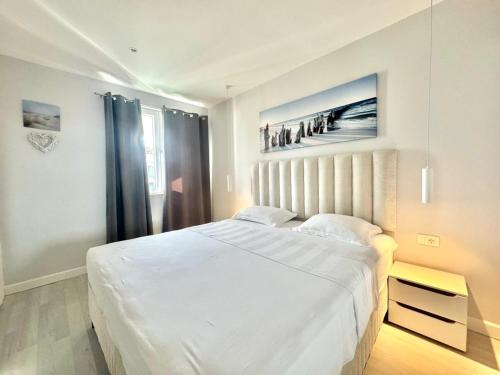 a white bedroom with a large bed and a window at Family Apartments Stefan in Budva