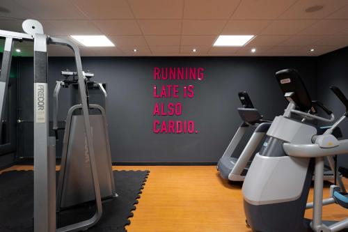 a gym with cardio equipment on a wall at Radisson Blu Hotel Dortmund in Dortmund