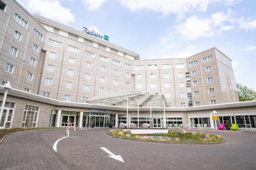 a large building with a courtyard in front of it at Radisson Blu Hotel Dortmund in Dortmund