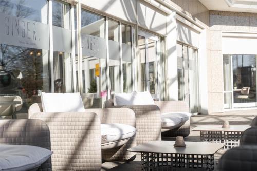 a patio with couches and tables in front of a store at Radisson Blu Hotel Dortmund in Dortmund