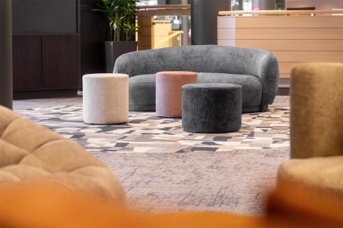 a living room with a couch andools on a rug at Radisson Blu Hotel Dortmund in Dortmund