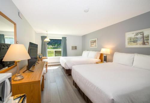 a hotel room with two beds and a television at Coast Hinton Hotel in Hinton