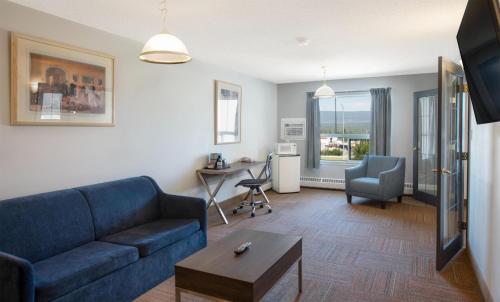 a living room with a blue couch and a table at Coast Hinton Hotel in Hinton