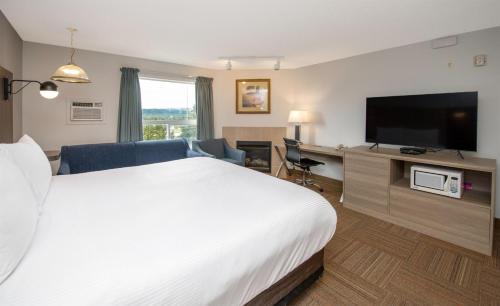 a hotel room with a bed and a flat screen tv at Coast Hinton Hotel in Hinton