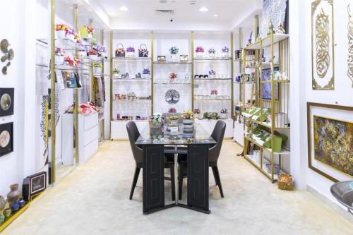 a dining room with a table and shelves of vases at Radisson Hotel Muscat Panorama in Muscat