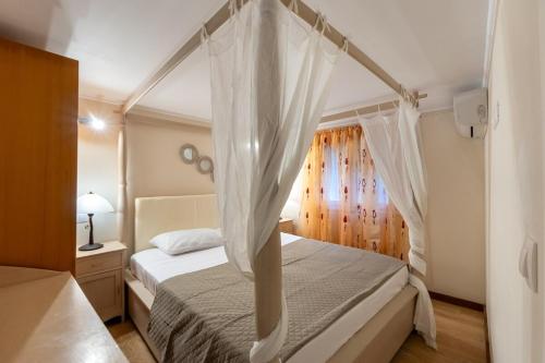 a bedroom with a bed with a canopy at Vasilis Family House in Ágios Rókkos