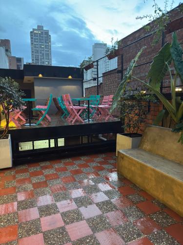 a rooftop patio with colorful chairs and a table at Hostel43 in Estación El Salto