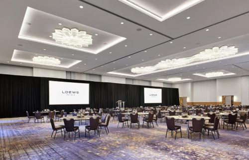 a conference room with tables and chairs and two screens at Loews Chicago Hotel in Chicago