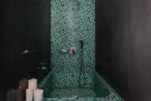 a bathroom with a shower with candles in it at Sweet Pop in Fira