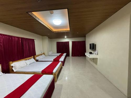 Una habitación de hotel con tres camas y un televisor. en StayInnBaguio Transient, en Sampong