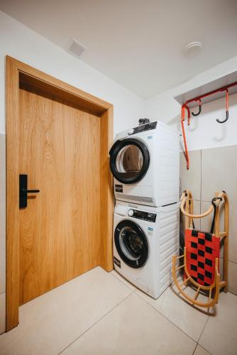a washer and dryer in a room with a door at Vila Roháčka - Luxusná Vila so súkromným wellness a bazénom in Habovka