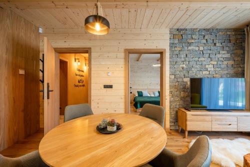 a dining room with a wooden table and a television at Vila Roháčka - Luxusná Vila so súkromným wellness a bazénom in Habovka
