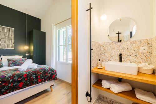 a bedroom with a bed and a mirror and a sink at Villa évasion familiale avec Piscine & Mer à 200m in Rivedoux-Plage