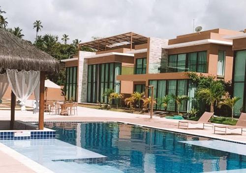 a house with a swimming pool in front of a building at Casa Milagres Morada do Toque l até 6 adultos in São Miguel dos Milagres