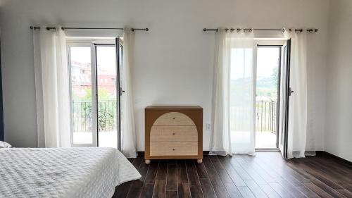 Fonte NuovaにあるLa villa di Arianna - Comfort Houseのベッドと2つの大きな窓がある寝室