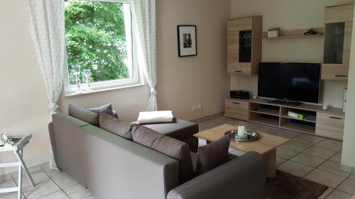 ein Wohnzimmer mit einem Sofa und einem TV in der Unterkunft Ferienwohnung Jürgens in Rheinbreitbach