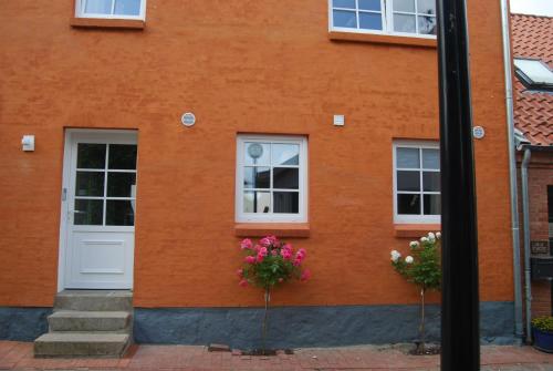 a building with two windows and flowers in front of it at Haus Adria in Schleswig