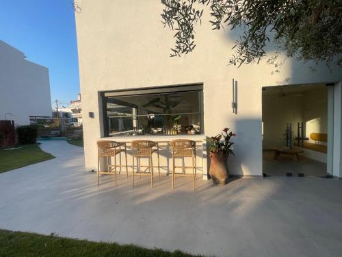 a patio with a table and chairs in front of a building at Olvion Luxury Living in Kallithea Halkidikis