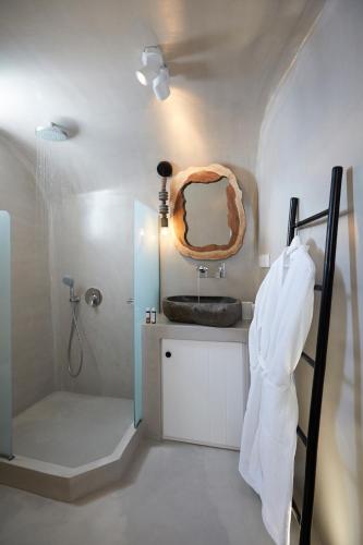 a bathroom with a sink and a mirror at Olea Cave House in Imerovigli