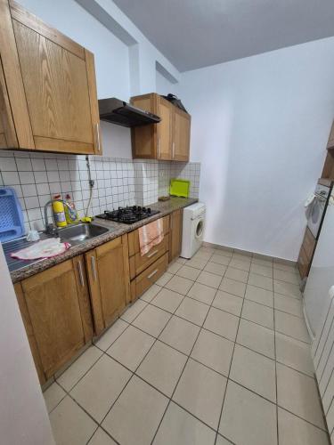 a small kitchen with wooden cabinets and a sink at Residence Essarh in Hiboun