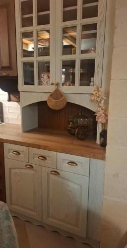 a kitchen with white cabinets and a wooden counter top at Villa Quercus in Alikampos