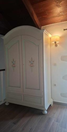 a white cabinet in a room with a wooden ceiling at Villa Quercus in Alikampos