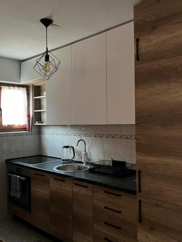a kitchen with white cabinets and a sink at Vikendica u srcu Bjelasnice in Trnovo
