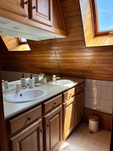 a bathroom with two sinks and a wooden wall at Gîte de charme La Pradelle in Prats-du-Périgord