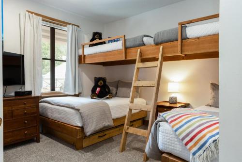 a bedroom with two bunk beds and a television at 118 Villa Montane in Avon